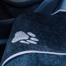 Load image into Gallery viewer, Close-up of a textured dark blue fabric with a white logo on a black background