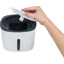 Load image into Gallery viewer, Hand placing a white lid on a black and white container with a white background