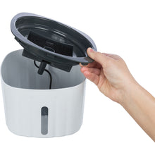 Load image into Gallery viewer, Hand holding a gray lid over a white container with a black interior on a white background