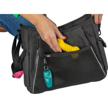 Load image into Gallery viewer, Black pet carrier with a yellow dog toy inside, held by a person.