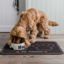Load image into Gallery viewer, Dog drinking from a bowl on a 'Pet Rebellion' mat with a paw design.
