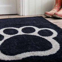 Load image into Gallery viewer, Black doormat with a large white paw print on a wooden floor.
