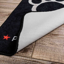 Load image into Gallery viewer, Close-up of a black and white sock with red star on a wooden floor.
