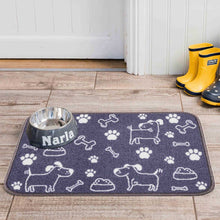 Load image into Gallery viewer, Pet mat with paw prints and dog illustrations on a wooden floor, next to a metal bowl and yellow boots.
